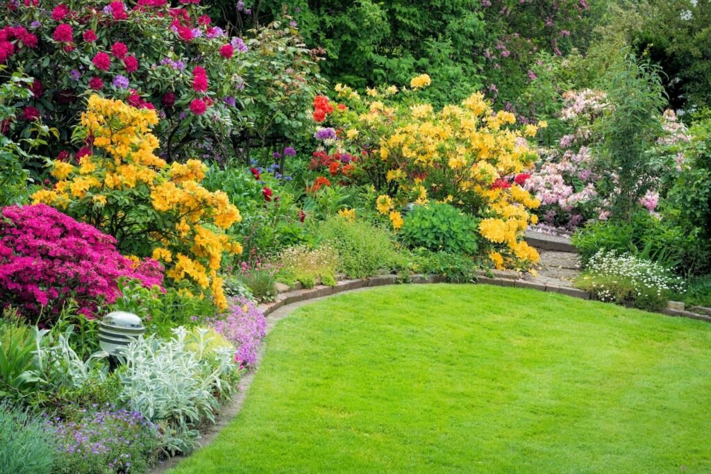 Jardín con césped verde y flores.